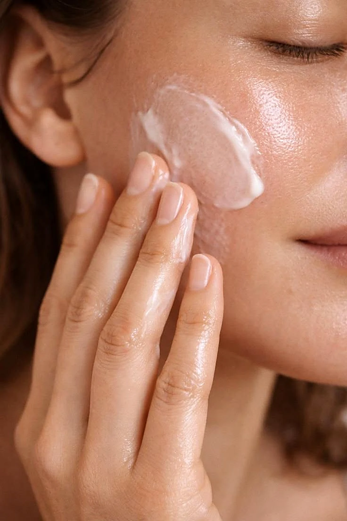 Aplicación de la crema facial reparadora sobre el pómulo con movimientos ascendentes.